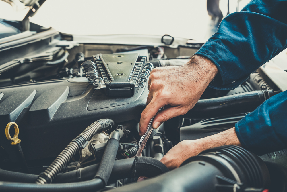 mécanicien réparant un moteur de voiture